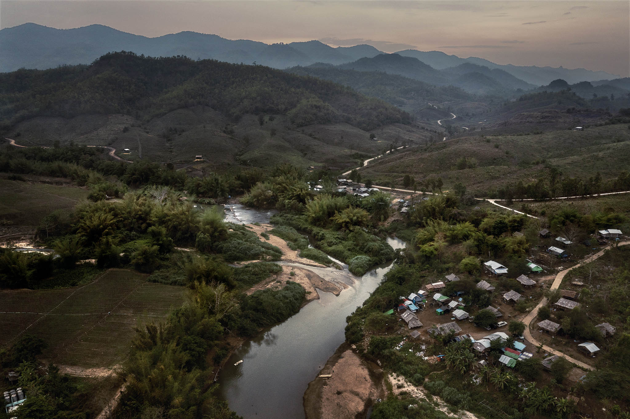 A camp for people displaced by fighting along the Moei River, which separates Thailand, left, from Myanmar, March 7, 2022. (Adam Dean/The New York Times)