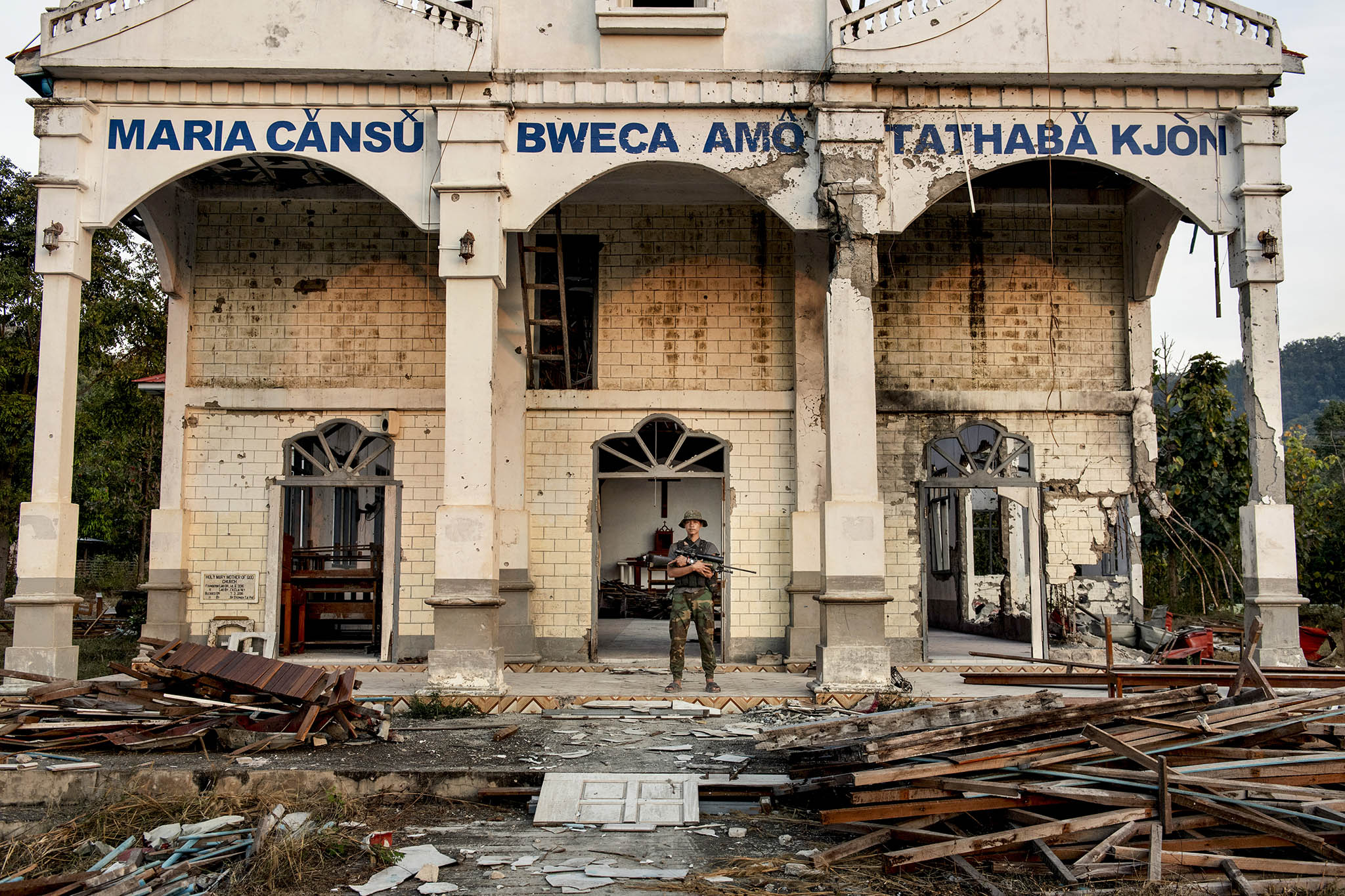 Soldiers from an armed insurgent group walk through a church damaged by the military in southern Karenni State in Myanmar. January 28, 2024. (Adam Ferguson/The New York Times)