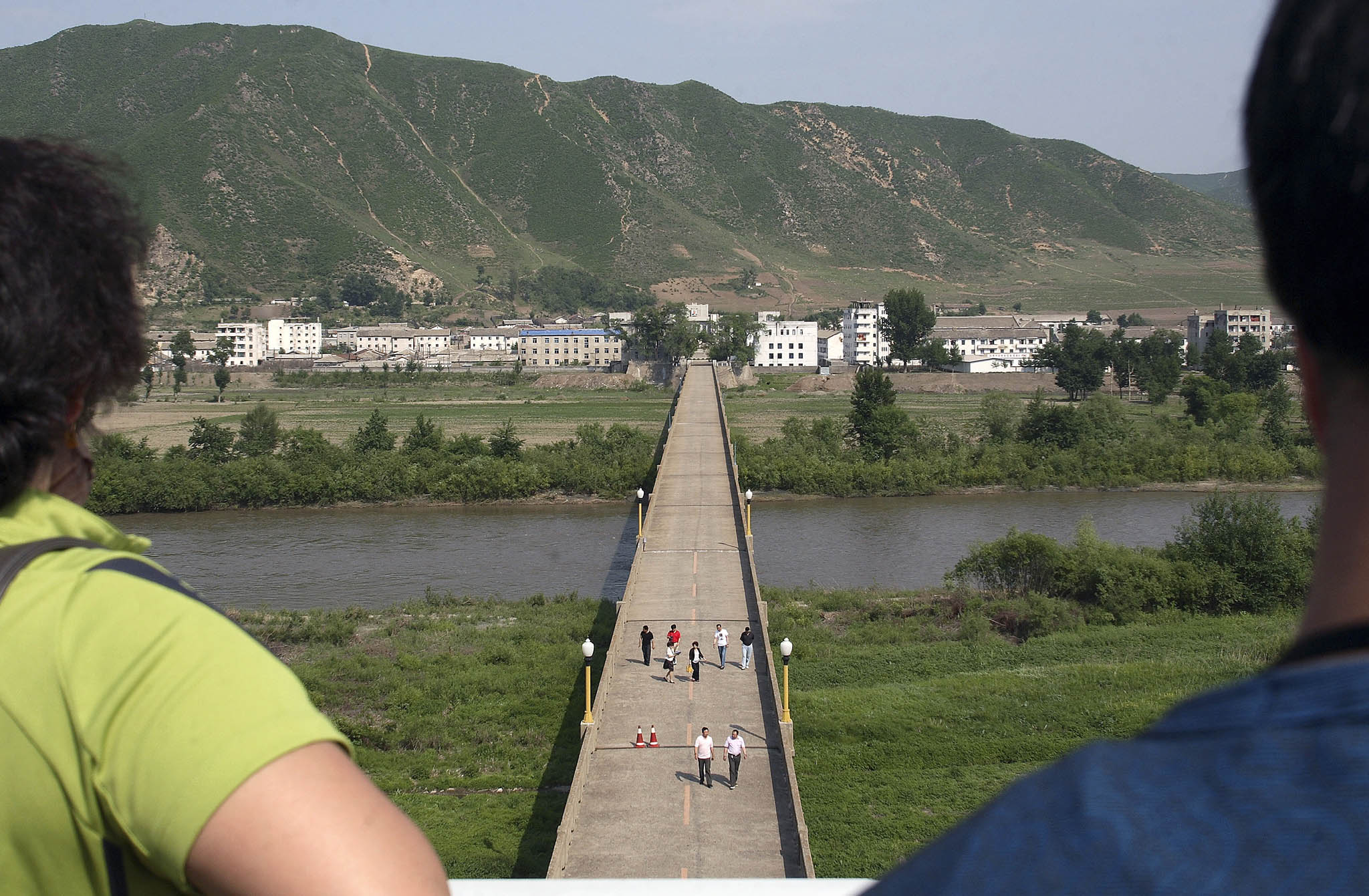 Tourists look across the Tumen River at the town of Nanyang in North Korea, in Tumen, China. June 6, 2010. (Du Bin/The New York Times)