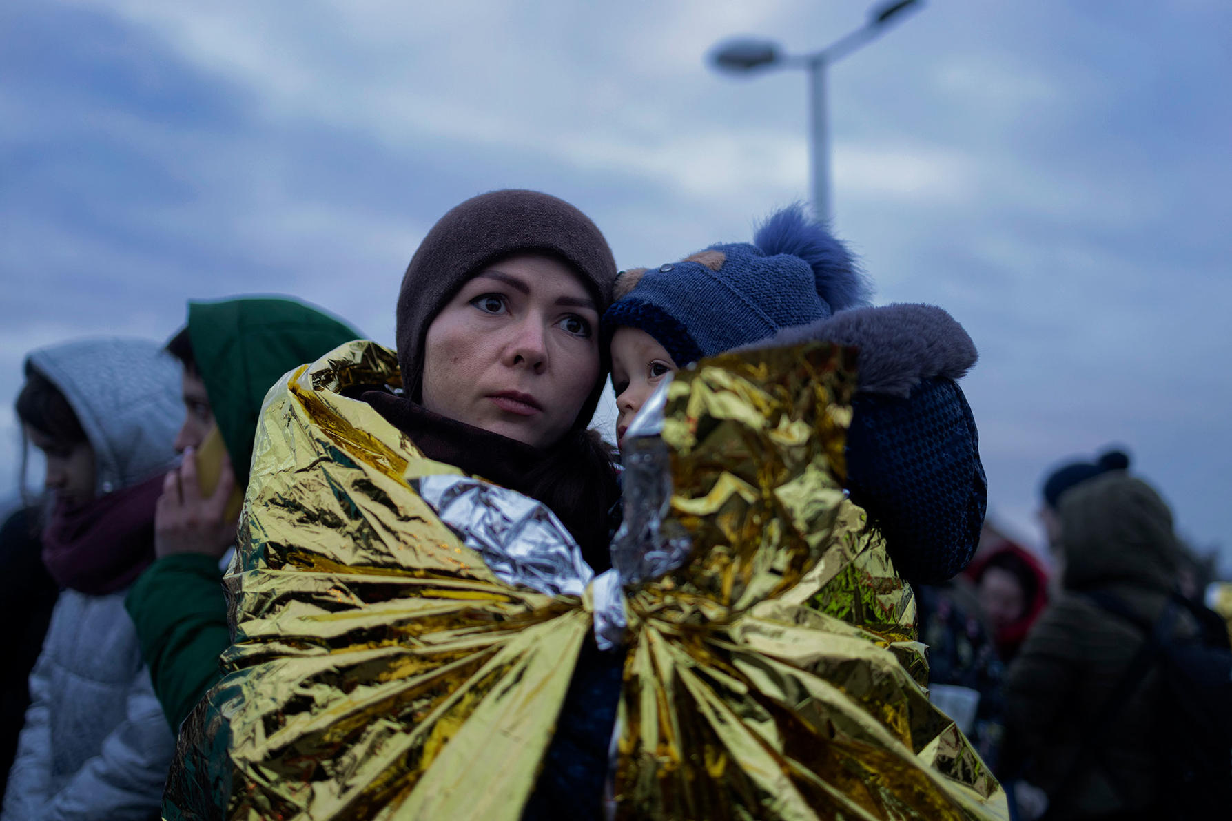 Refugees from Ukraine wait for a bus to continue their journey after crossing the Polish border at Medyk, Poland.
