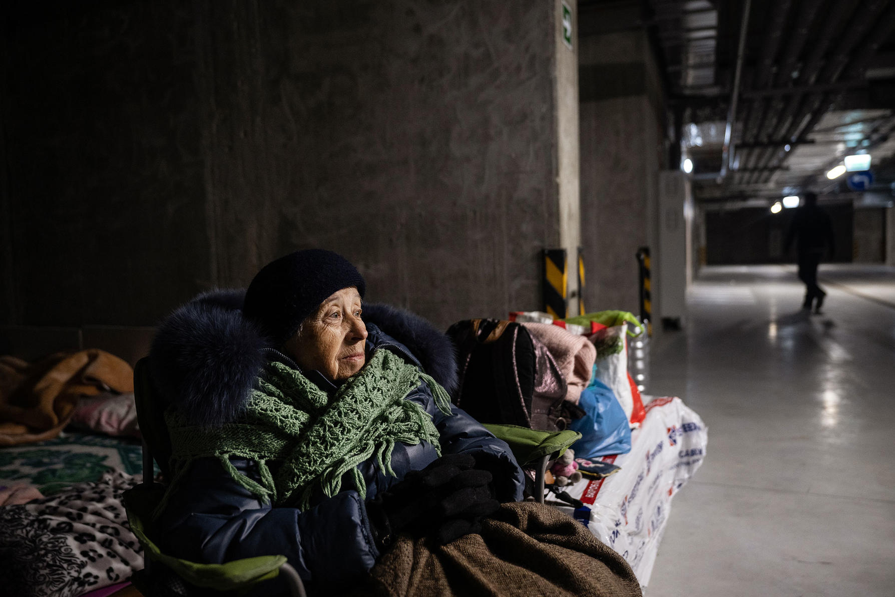Svetlana Akimova shelters in a parking garage after heavy fighting took place outside her apartment building in Kyiv, Ukraine, on Saturday, Feb. 26, 2022. (Lynsey Addario/The New York Times)