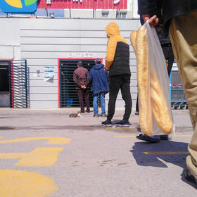 Tunisians wait in line to enter a grocery store amid COVID-19 lockdown measures. March 27, 2020. (Brahim Guedich/Wikimedia Commons)