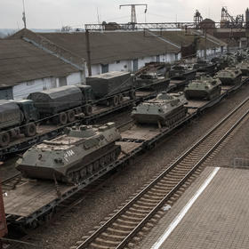 Armored personnel carriers and military trucks are loaded on train cars outside Taganrog, Russia, Feb. 23, 2022. (The New York Times)