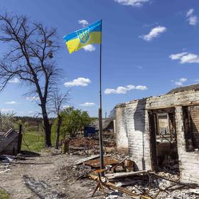 The flag of Ukraine flies over the wreckage of a home in the village of Moschun, north of Kyiv, on Tuesday, May 10, 2022. Kersti Kaljulaid, a former president of Estonia, wants the West to enhance its support for Ukraine. (David Guttenfelder/The New York