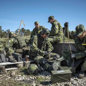 Troops with the Gotland regiment of the Swedish Army reload their machine guns during target practice on Gotland Island, Sweden, on May 11, 2022. (Sergey Ponomarev/The New York Times)
