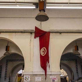 A tattered Tunisian flag at a market in downtown Tunis, Sept. 28, 2021. (Ivor Prickett/The New York Times)