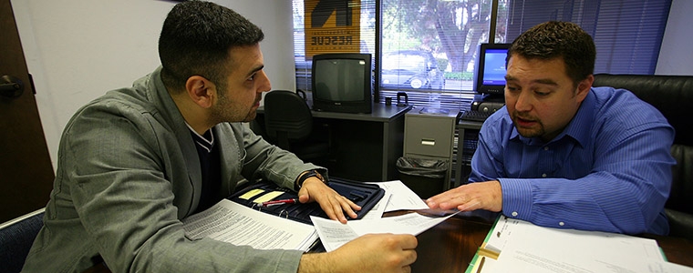 26-year-old Iraqi refugee, left, working on his resume with Sead Eminovic
