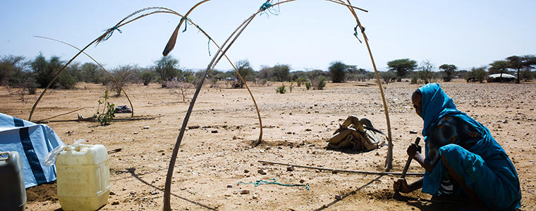 A woman builds a shelter for herself in the village of Damra Toma in North Darfur State, Sudan.