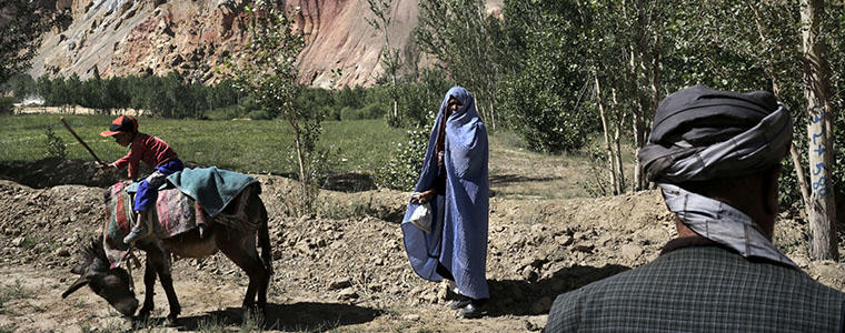 A donkey carrying a young boy grazes near Hajigak, which has large iron ore deposits, in Bamian, Afghanistan, July 4, 2012. An estimated $1 trillion of natural resources in Afghanistan, including oil, gold and copper, is waiting to be processed, but Afghans' hopes of self-sufficiency are tempered by concerns about corruption and security. (Mauricio Lima/The New York Times)