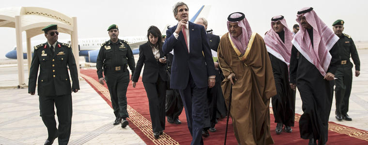 U.S. Sec. of State Kerry walks alongside FM Prince Saud al-Faisal. Kerry suggested that Iran might play a role during Syrian peace talks, the first time a senior American official has indicated that Iranian diplomats might participate. Photo Credit: The New York Times/Brendan Smialowski