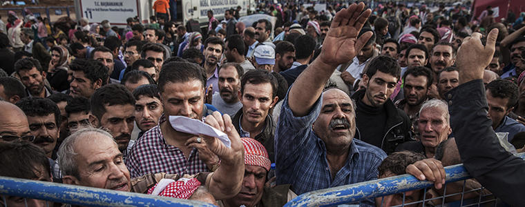 Syrian Kurdish refugees press against a gate as they hope to be allowed into Turkey at the Yumurtalik border crossing in Turkey, Sept. 29, 2014. Islamic State militants have been carrying out a weeklong assault on the Kurdish area across the border, where residents have pleaded for military aid. (Bryan Denton/The New York Times)