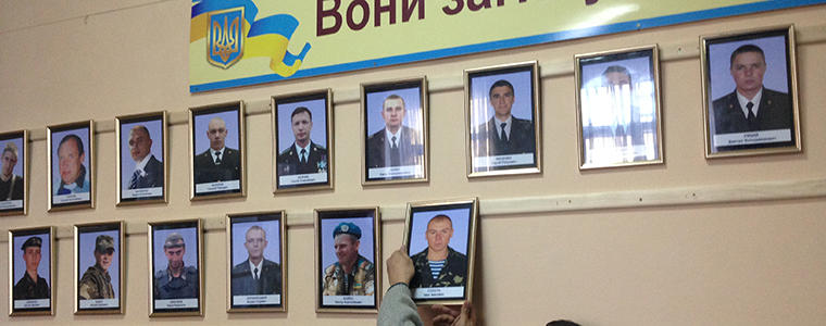 Worker at the regional administration building in Kirovograd hangs portraits of soldiers killed in Ukraine’s conflict.