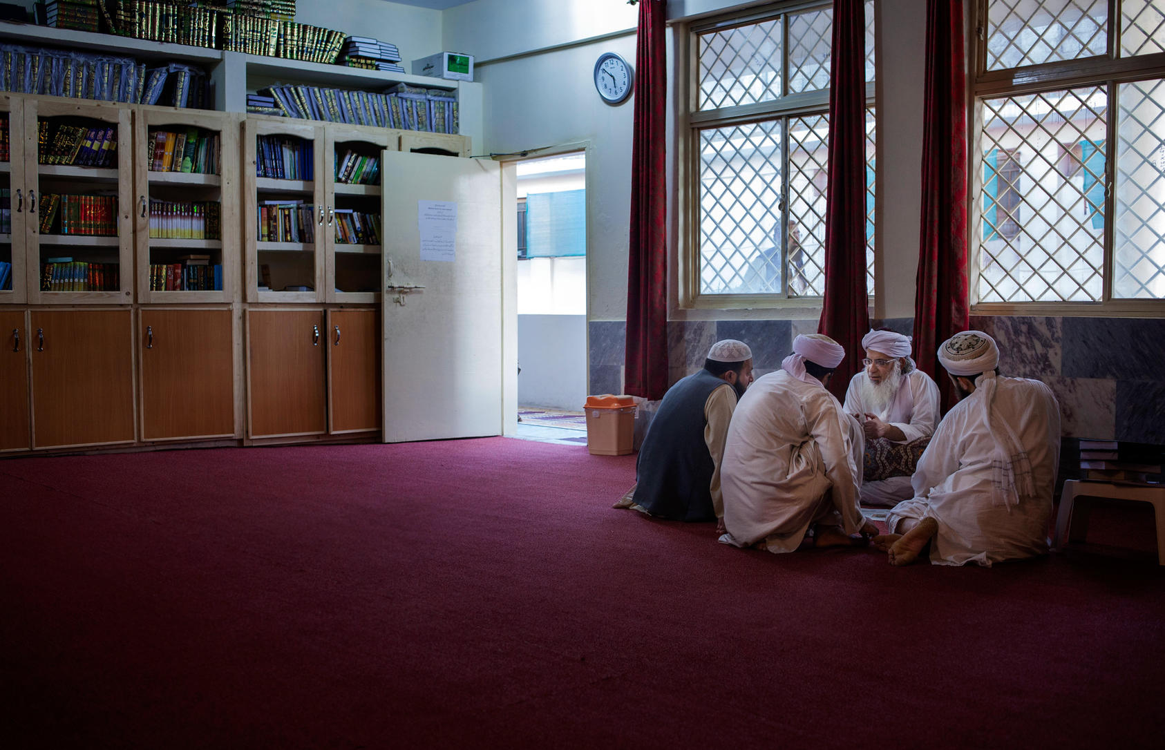 Maulana Abdul Aziz, second from right, chief cleric of the Red Mosque, speaks with visitors at the Red Mosque library named for Osama bin Laden in Islamabad, Pakistan, April 26, 2014. Photo Credit: The New York Times/Myra Iqbal