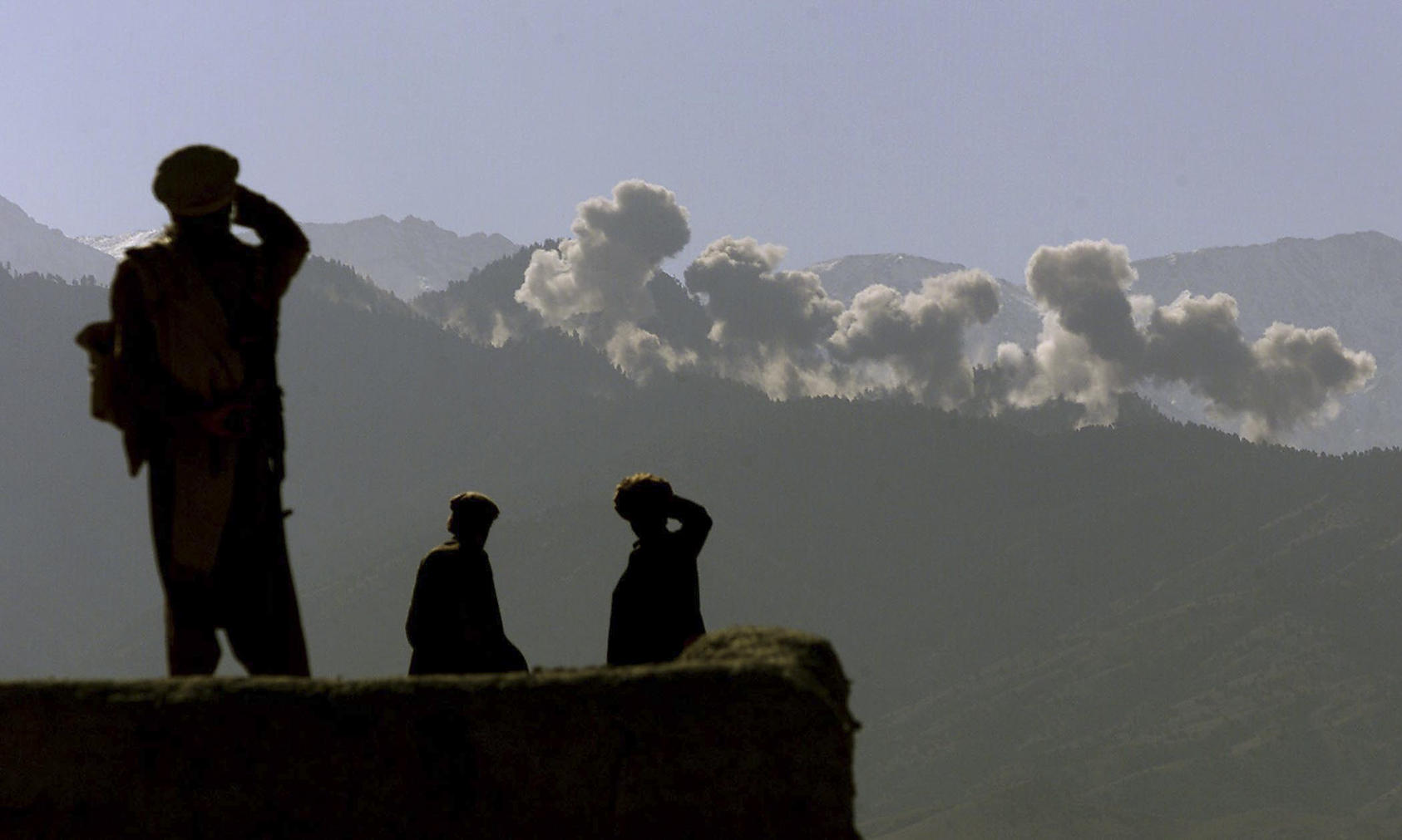 Eastern Shura fighters watch as U.S. B-52’s carpet bomb an area of the Tora Bora mountains in Afghanistan