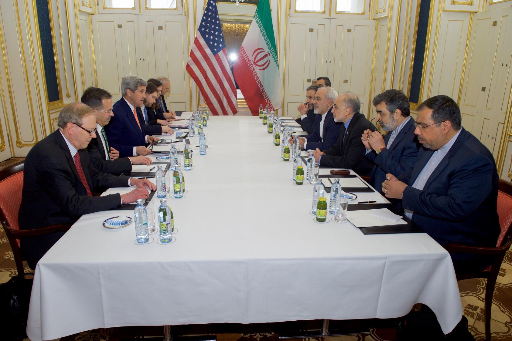 U.S. Secretary of State John Kerry, Iranian Foreign Minister Javad Zarif, and their respective advisers sit across from one another on January 16, 2016, at the Palais Coburg Hotel in Vienna, Austria, before a meeting about the implementation of the Joint Comprehensive Plan of Action outlining the shape of Iran's nuclear program.