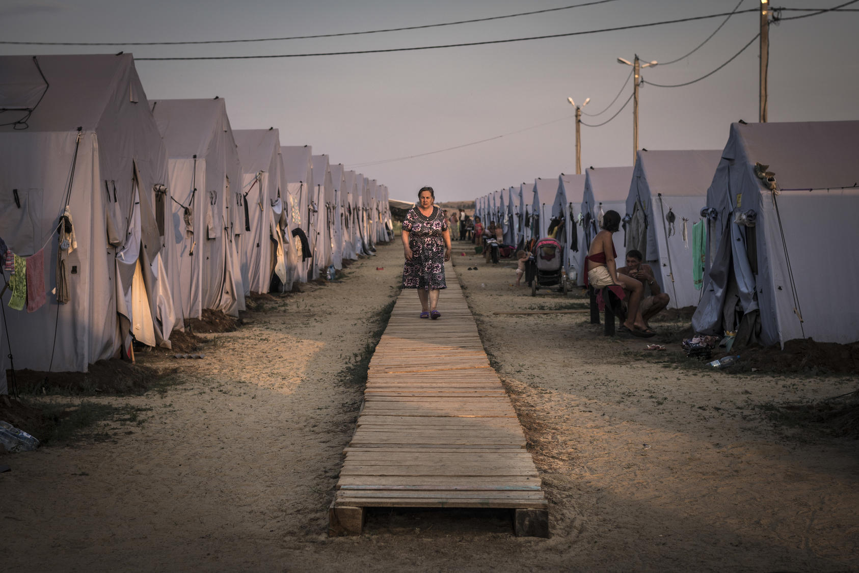 A woman walks among the tents at a refugee camp in Donetsk, Aug. 22, 2014. The United Nations reports that more than a million Ukrainians have been displaced by war. (Sergey Ponomarev/The New York Times)