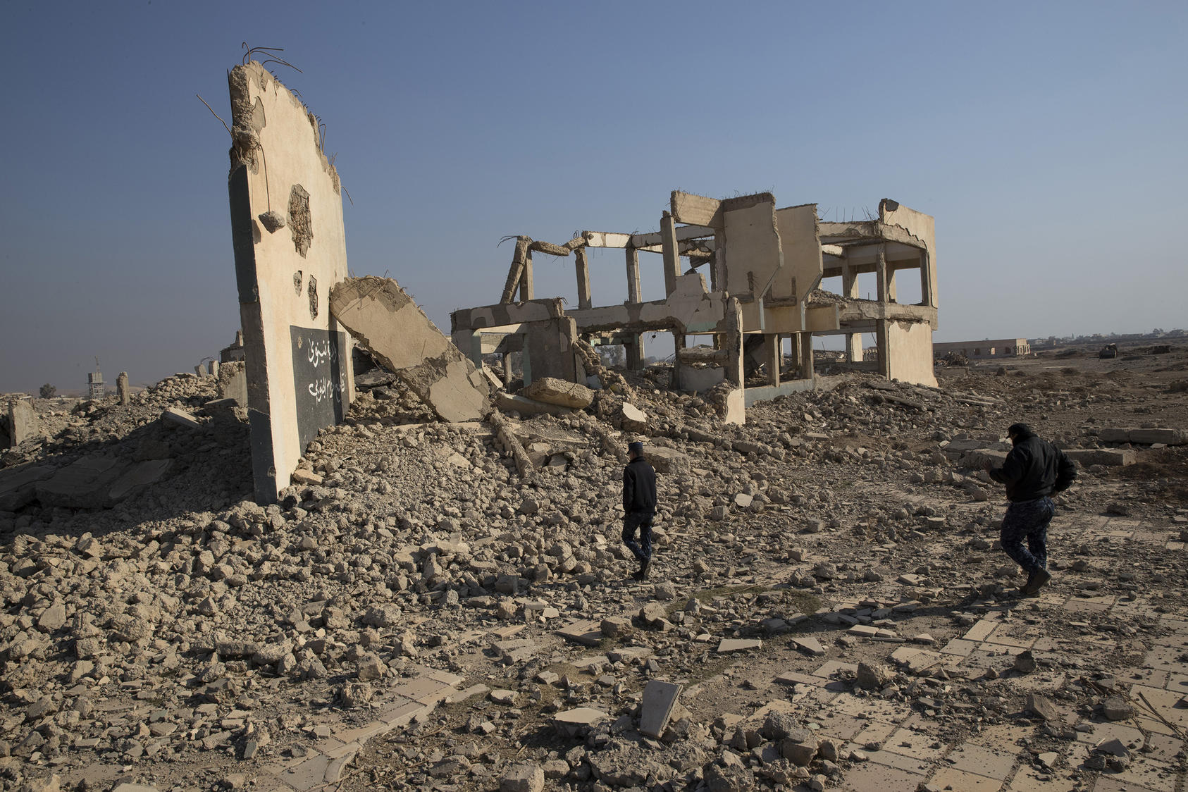 Writing left by Islamic State fighters remains visible on the wall of a building destroyed by a coalition airstrike in Hamam Alil, a former agricultural college town in Iraq, Dec. 11, 2016. Iraqi forces have been told to destroy evidence of the Islamic State’s presence as they retake areas in and around Mosul, but it is not always the easiest of tasks. (Tyler Hicks/The New York Times)