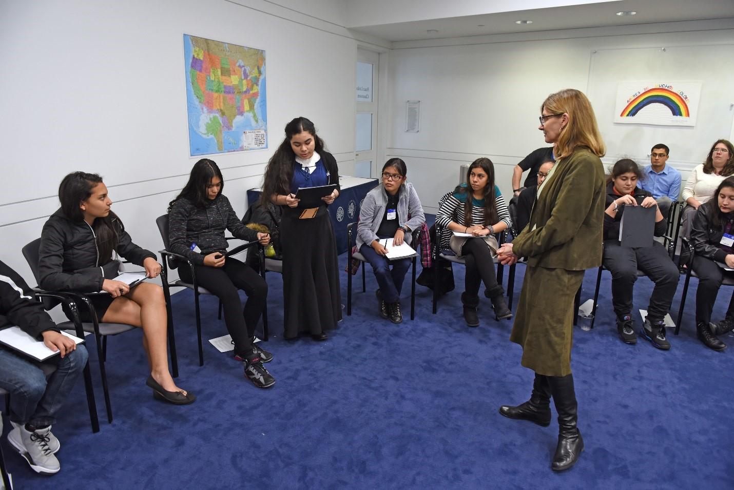 Brightwood Education Campus student reads a poem about peace to USIP President Nancy Lindborg.