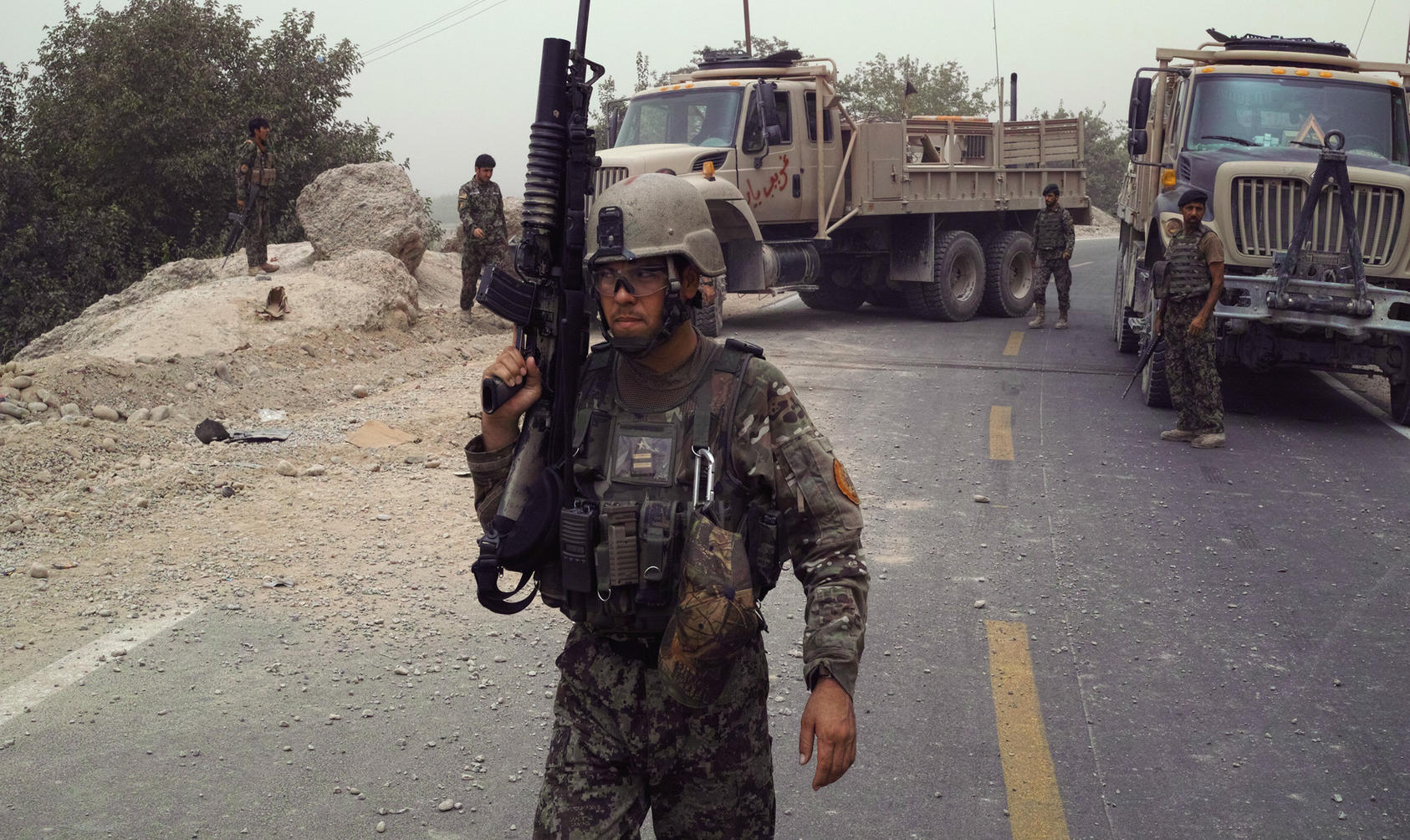 Capt. Said Kamal Sayeed keeps watch while fellow Afghan National Army soldiers work to repair a vehicle disabled in a Taliban ambush in Sangin, Afghanistan, Aug. 15, 2013. Photo Courtesy of The New York Times/Tyler Hicks