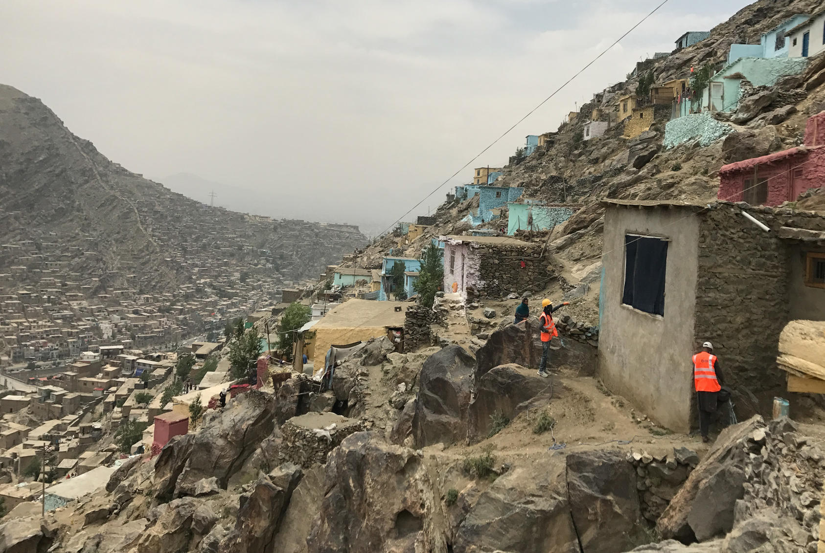 An undated photo of painters beginning to add color to the front of a home on a hillside in Kabul, Afghanistan, an attempt by the municipality to make the sprawl look nicer. The city, one of the fastest growing in the world, has already expanded to more than five times its intended size. 