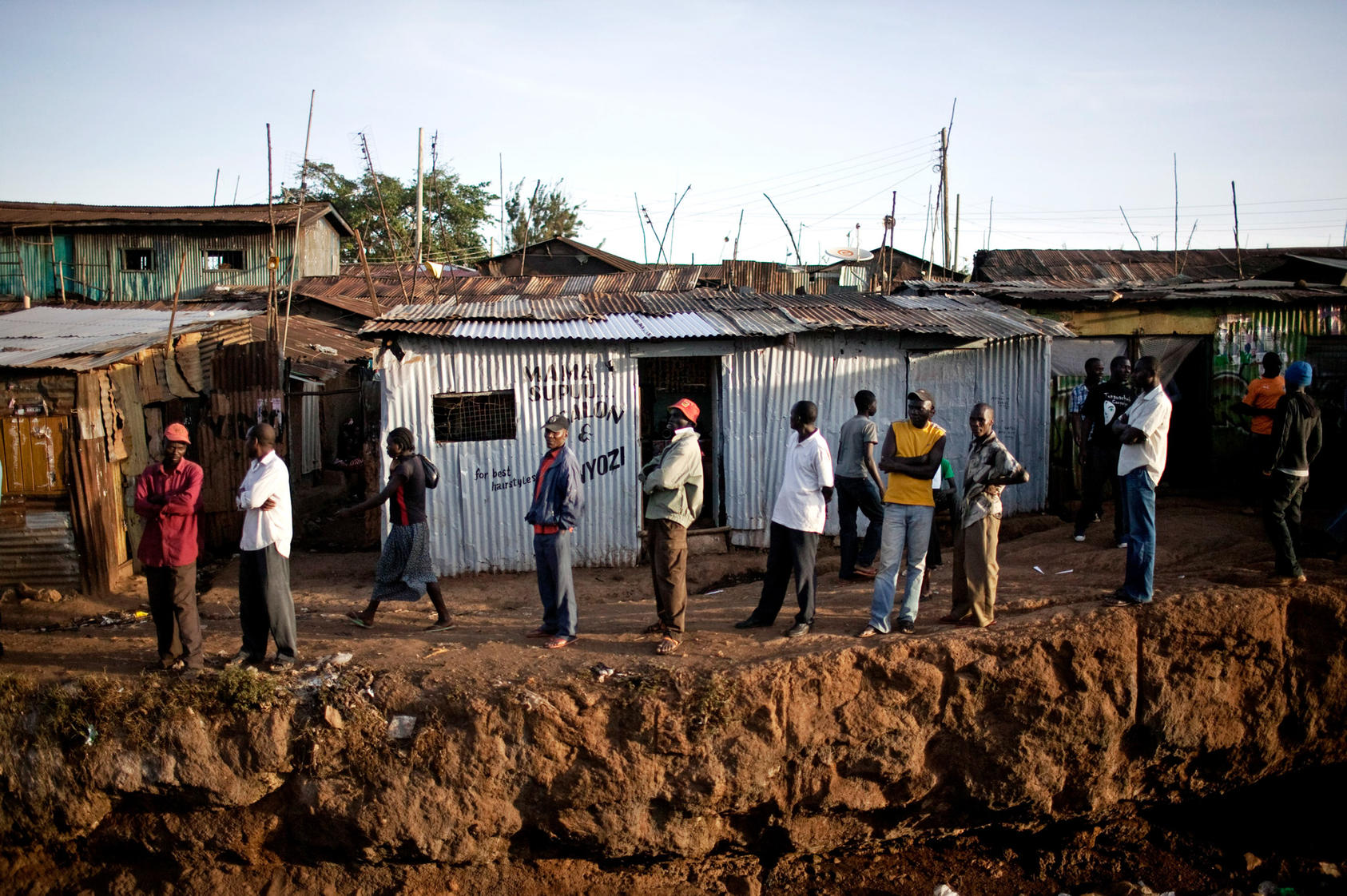 Residents look on as supporters of presidential candidate Raila Odinga gather in the Kibera area of Nairobi, Kenya. Photo Courtesy of The New York Times/Pete Muller