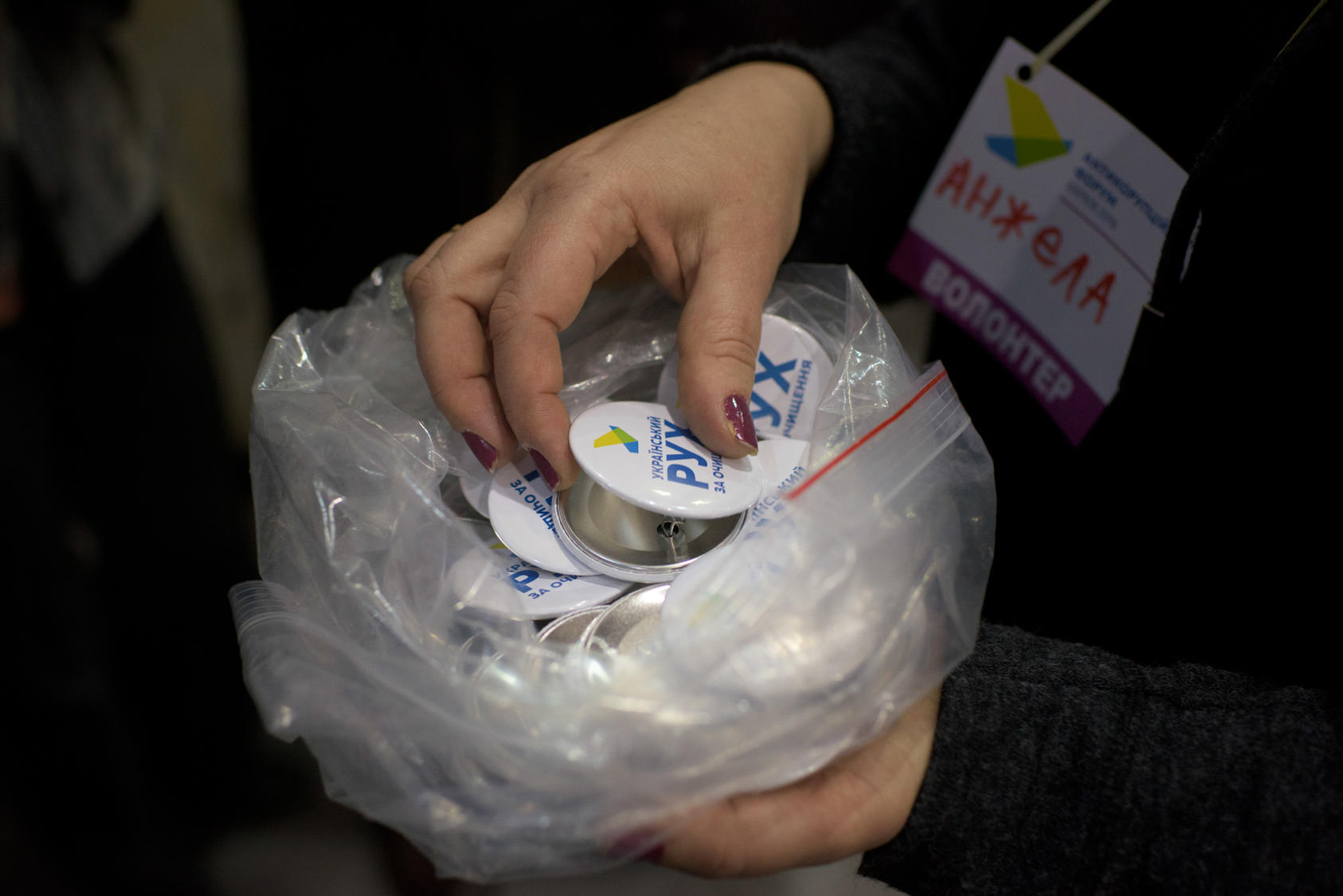 A volunteer distributes buttons for the Cleaning Up Ukraine movement at am anti-corruption forum where Mikheil Saakashvili delivered a speech, in Kharkiv, Ukraine, Jan. 18, 2016. Saakashvili – the former president of Georgia and one of the post-Soviet era’s most contentious and best-known politicians in the region – is making a political comeback in Ukraine as the figurehead of a movement to strip oligarchs of their power. (Pete Kiehart/The New York Times) 