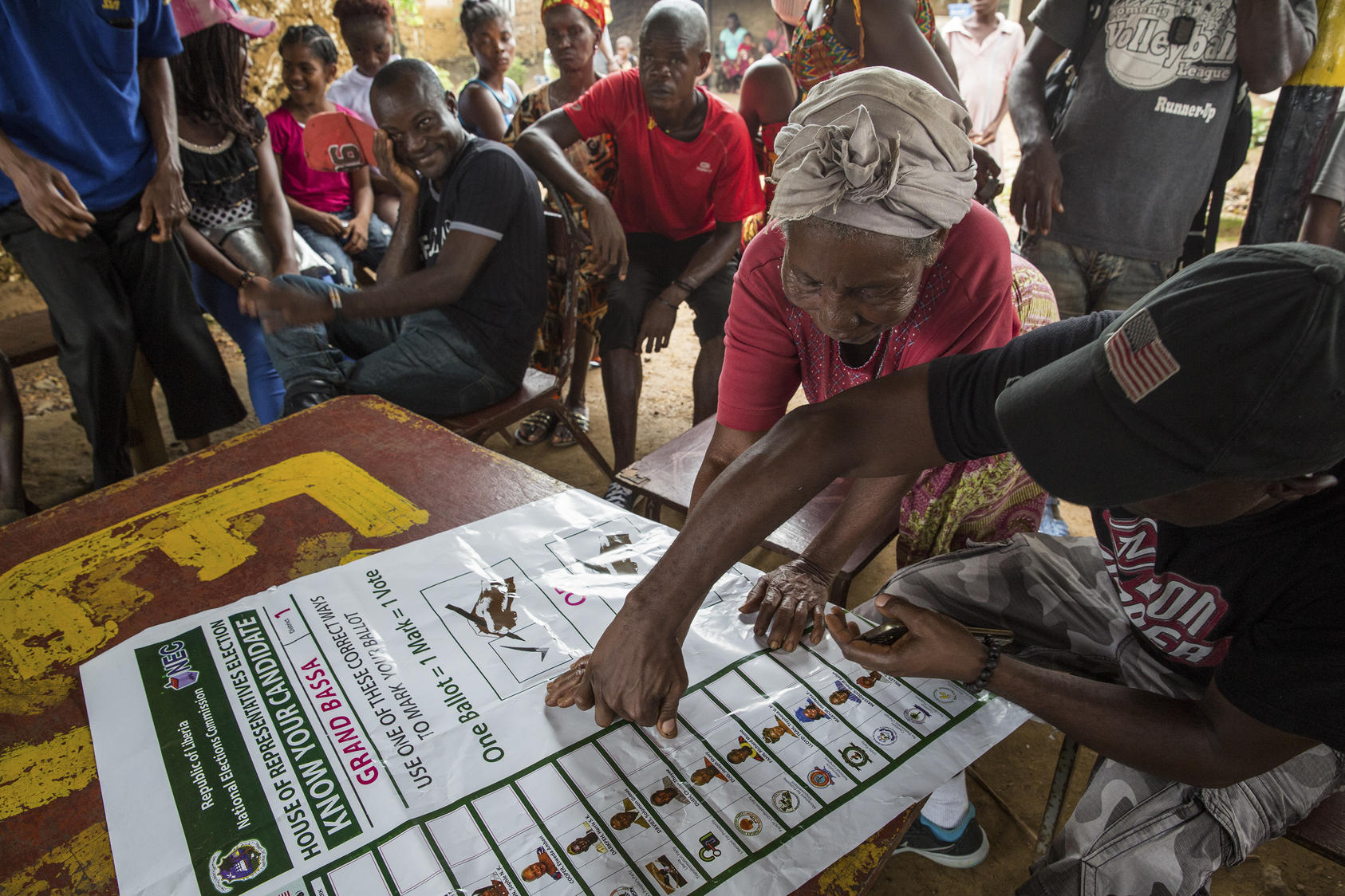 A member of Joseph Duo's campaign team shows a woman where the candidate's name will appear on the ballot in District One of Grand Bassa County, Liberia, Sept. 28, 2017. Duo, a onetime child soldier who returned to high school, studied criminal justice at a university and, among various other pursuits, once trained police officers, decided at the age of 40 to run for a seat in Liberia's legislature. (Carielle Doe/The New York Times) -- PART OF A COLLECTION OF STAND-ALONE PHOTOS FOR USE AS DESIRED IN YEAREND
