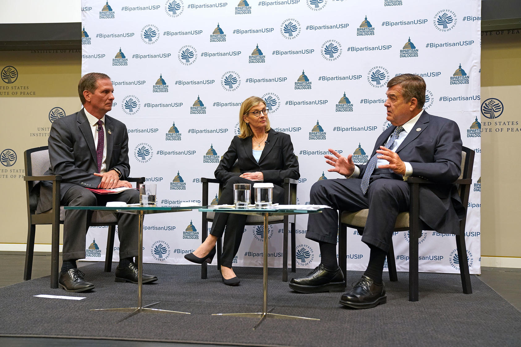 Representatives Chris Stewart of Utah, left, and Dutch Ruppersberger of Maryland, right, discuss U.S. China policy with USIP President Nancy Lindborg