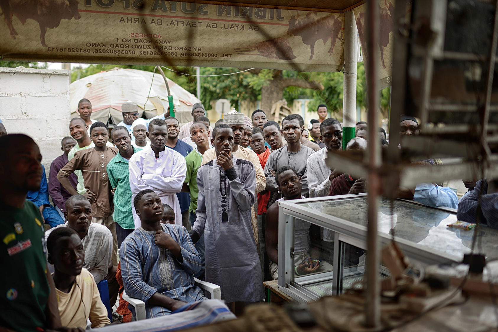 People gather and watch election coverage at a small market in Kano, northern Nigeria, March 31, 2015. (Samuel Aranda/The New York Times)