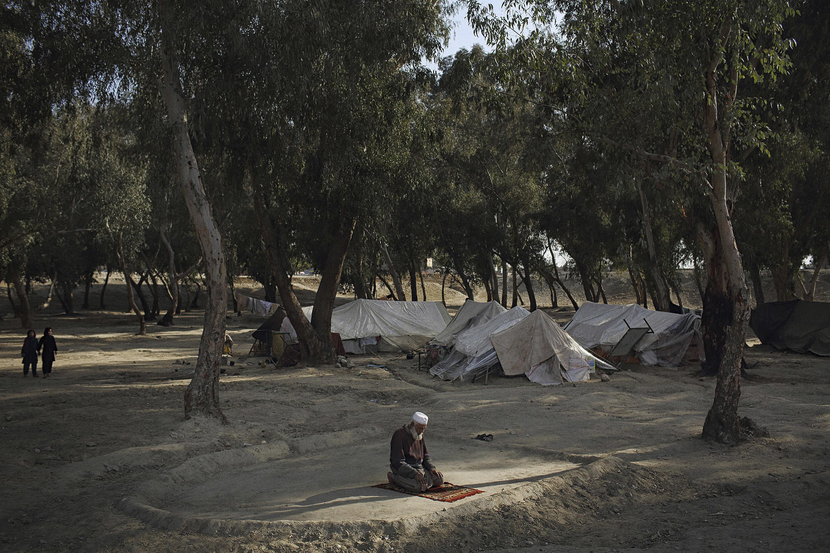 An Afghan man, Haji Hazrat, prays at a camp near Jalalabad in 2015 after he and other refugees in Pakistan were forced by authorities there to return to their homeland. (Andrew Quilty/The New York Times)