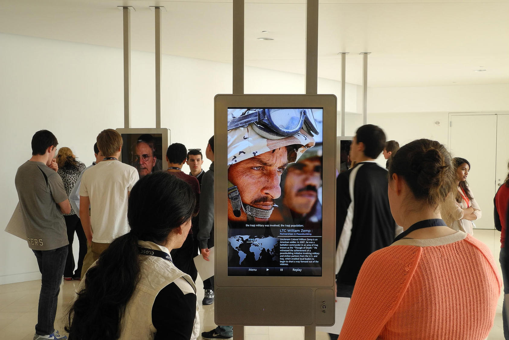 Students at USIP headquarters view the Witnesses to Peacebuilding exhibit, which uses multimedia and video to tell the powerful individual stories of peacebuilders of various types from around the world.