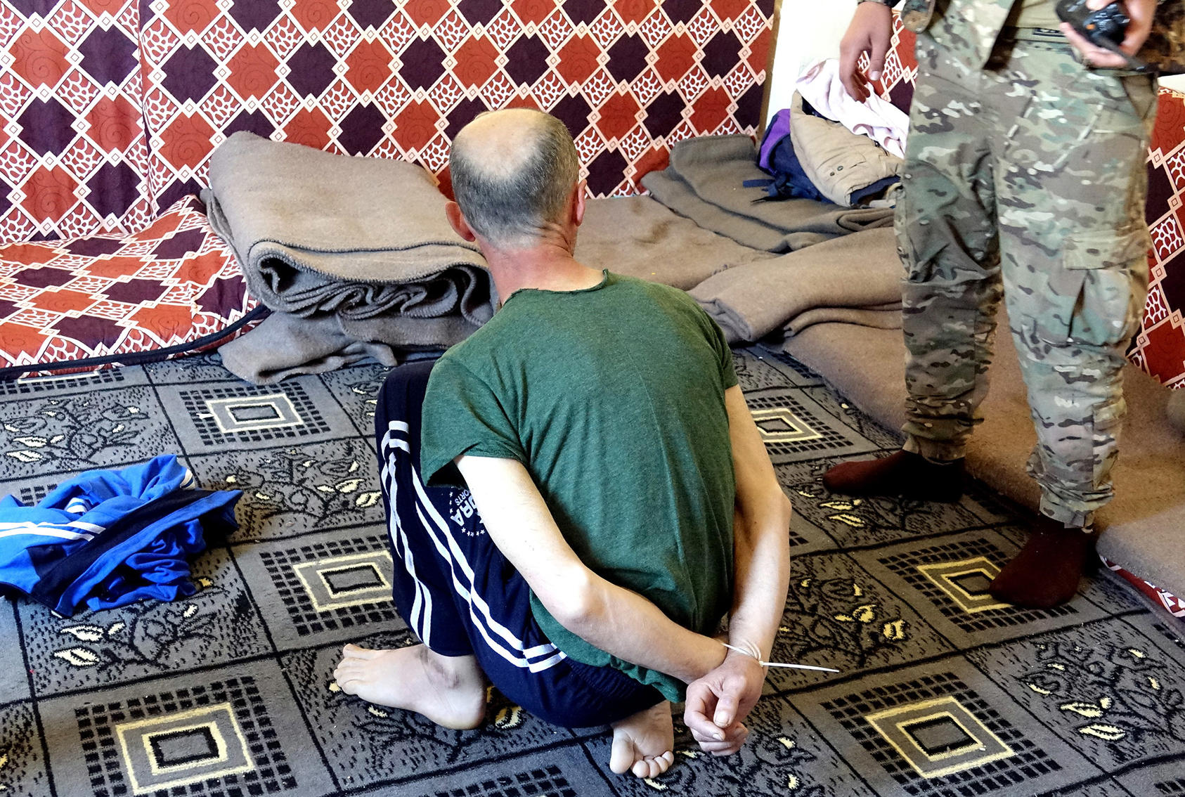An American ISIS member who surrendered to the Syrian Democratic Forces waits to be interviewed at a makeshift prison at Dashisha, Syria. (Photo credit: Robin Wright/USIP)
