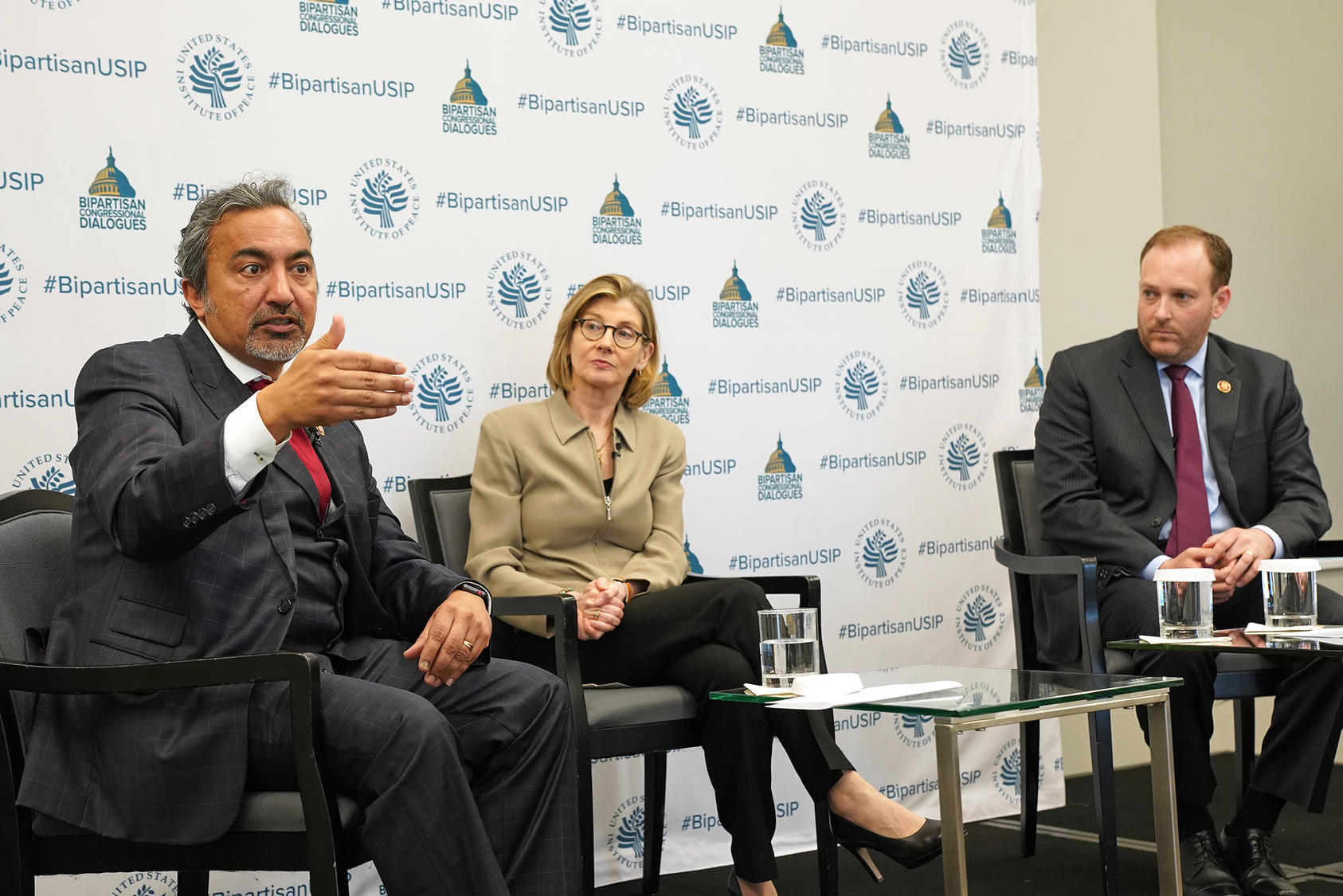 Representatives Ami Bera (D-CA), left, and Lee Zeldin (R-NY), right, talk with U.S. Institute of Peace President Nancy Lindborg, May 10, 2019. 