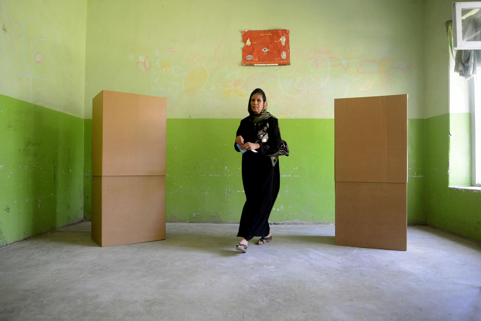 A voter walks to cast her ballot in 2014 during one of Afghanistan’s several recent disputed elections. Strengthening the credibility of elections is essential to sustaining voter turnout and governments’ legitimacy.