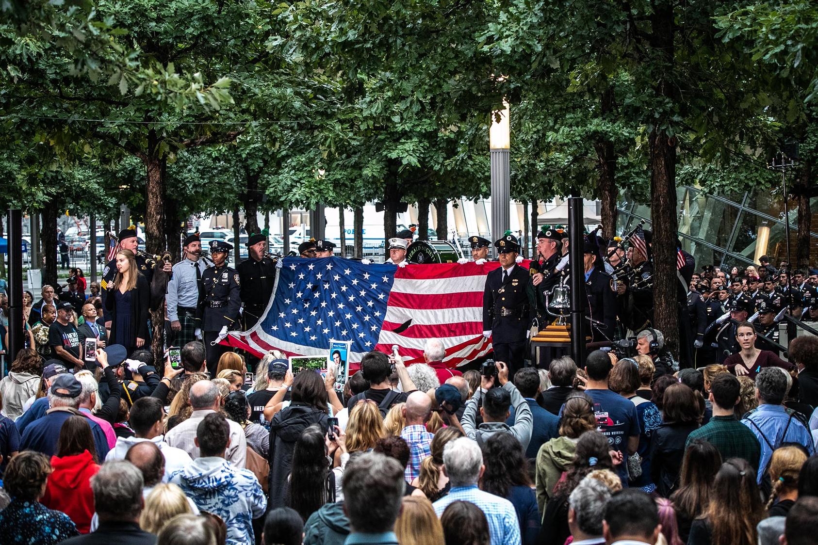 First responders hold an American flag that once flew over the World Trade Center towers, during the 17th anniversary of the Sept. 11 terrorist attacks, in New York, Sept. 11, 2018. (Jeenah Moon/The New York Times)
