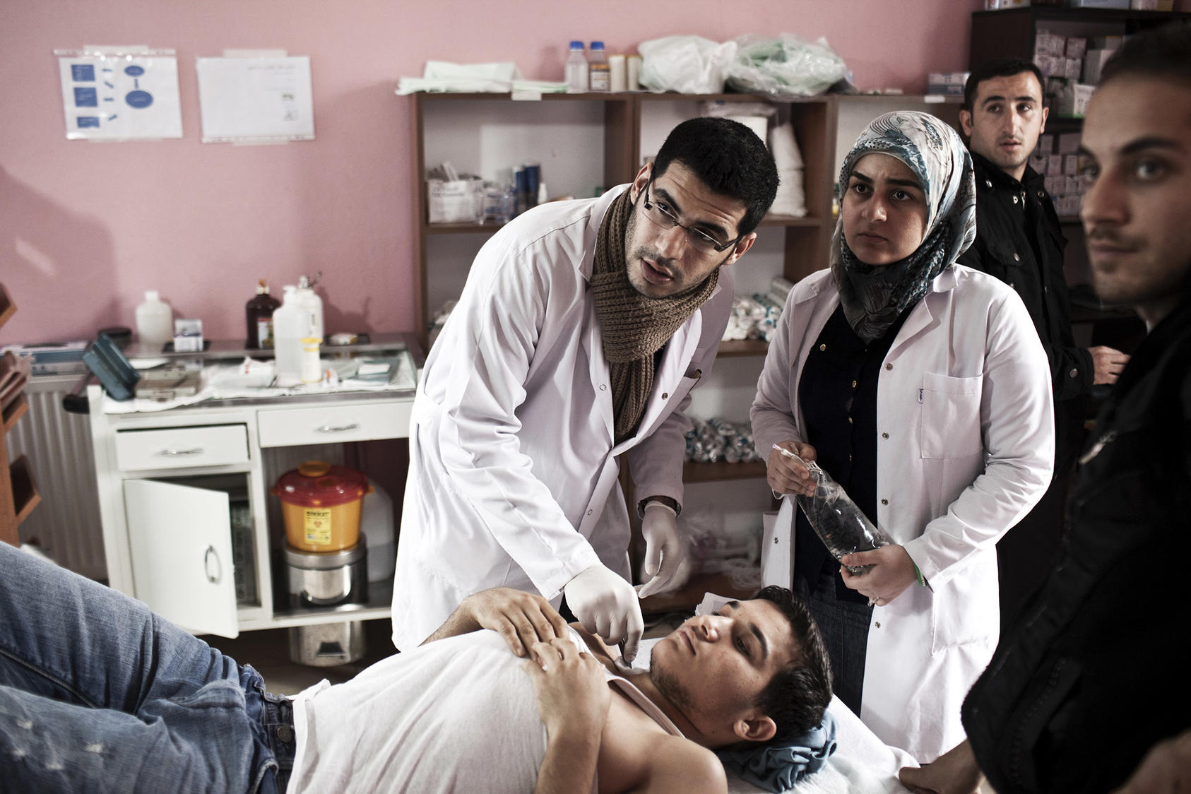 Dr. Housam Moustafa, a surgeon in training who fled Syria, treats a Syrian rebel at a clinic in Reyhanli, Turkey, March 3, 2013. (Daniel Etter/The New York Times)