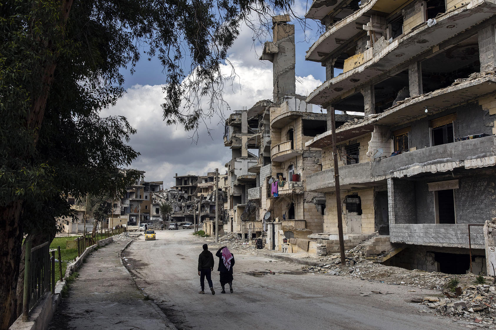 Two men walk through a heavily damaged neighborhood in Raqqa, Syria, on April 4, 2019, more than a year after the city’s liberation from the Islamic State. (Ivor Prickett/New York Times)