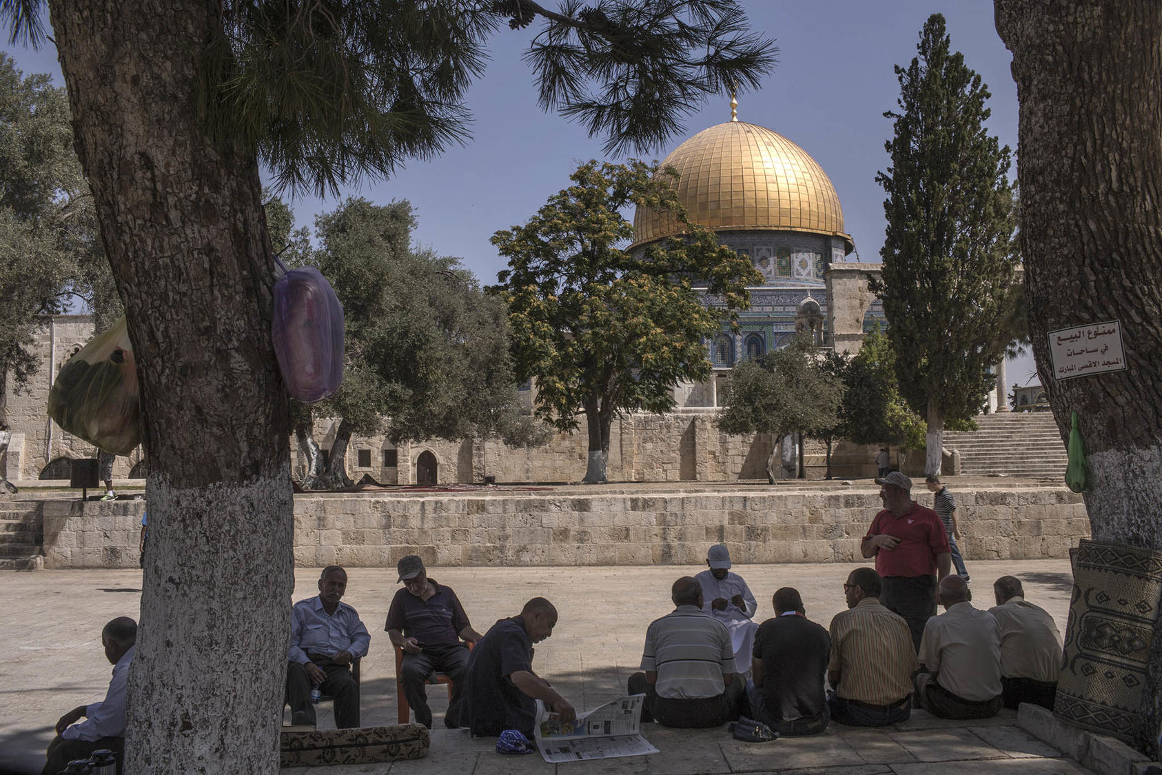 Locals sit near the Dome of the Rock in the Al-Aqsa Mosque compound in the Old City of Jerusalem, July 28, 2015. (Uriel Sinai/The New York Times)