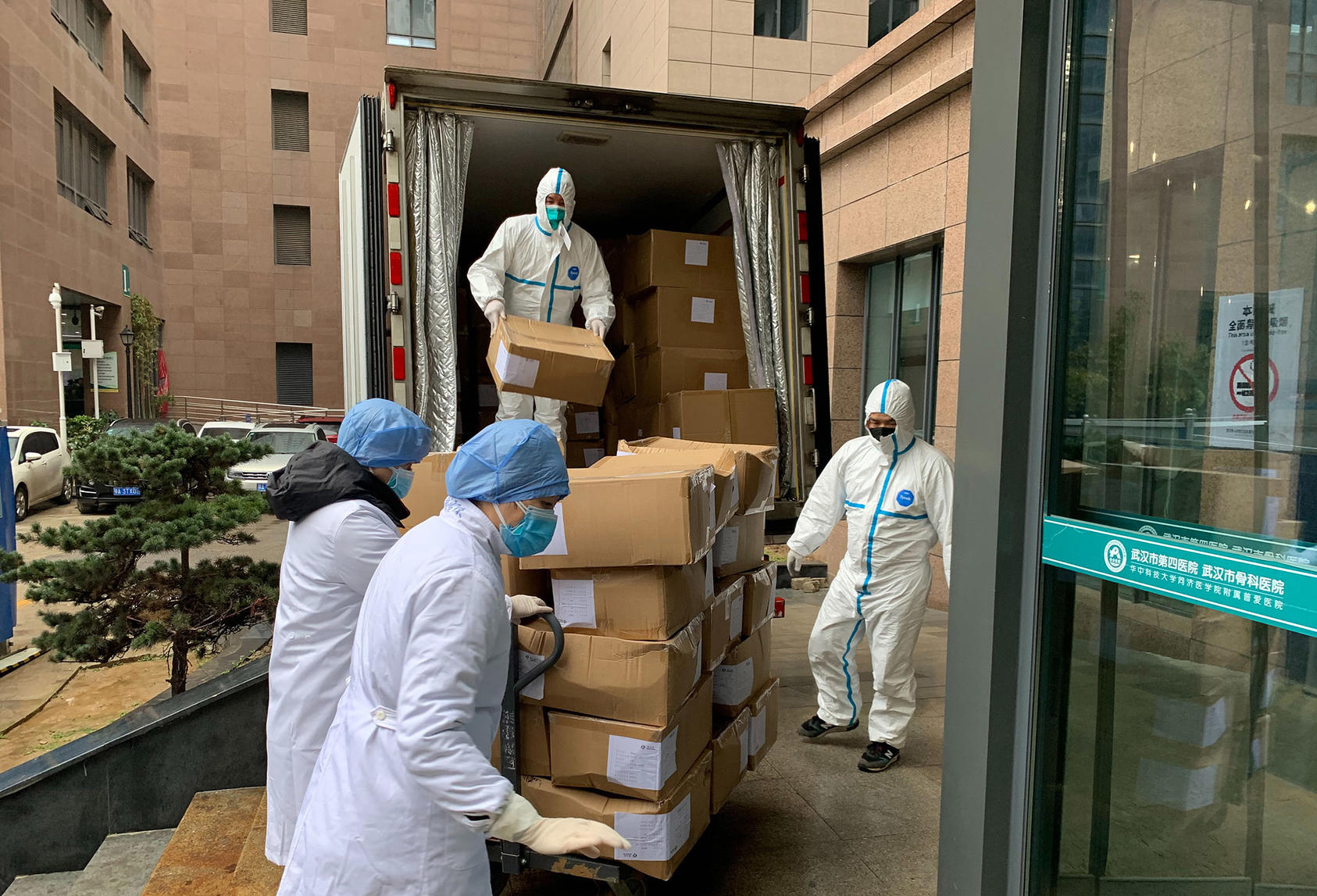 Workers unload shipments of medical gowns at a hospital in Wuhan, China on Jan. 24, 2020. (Chris Buckley/The New York Times)