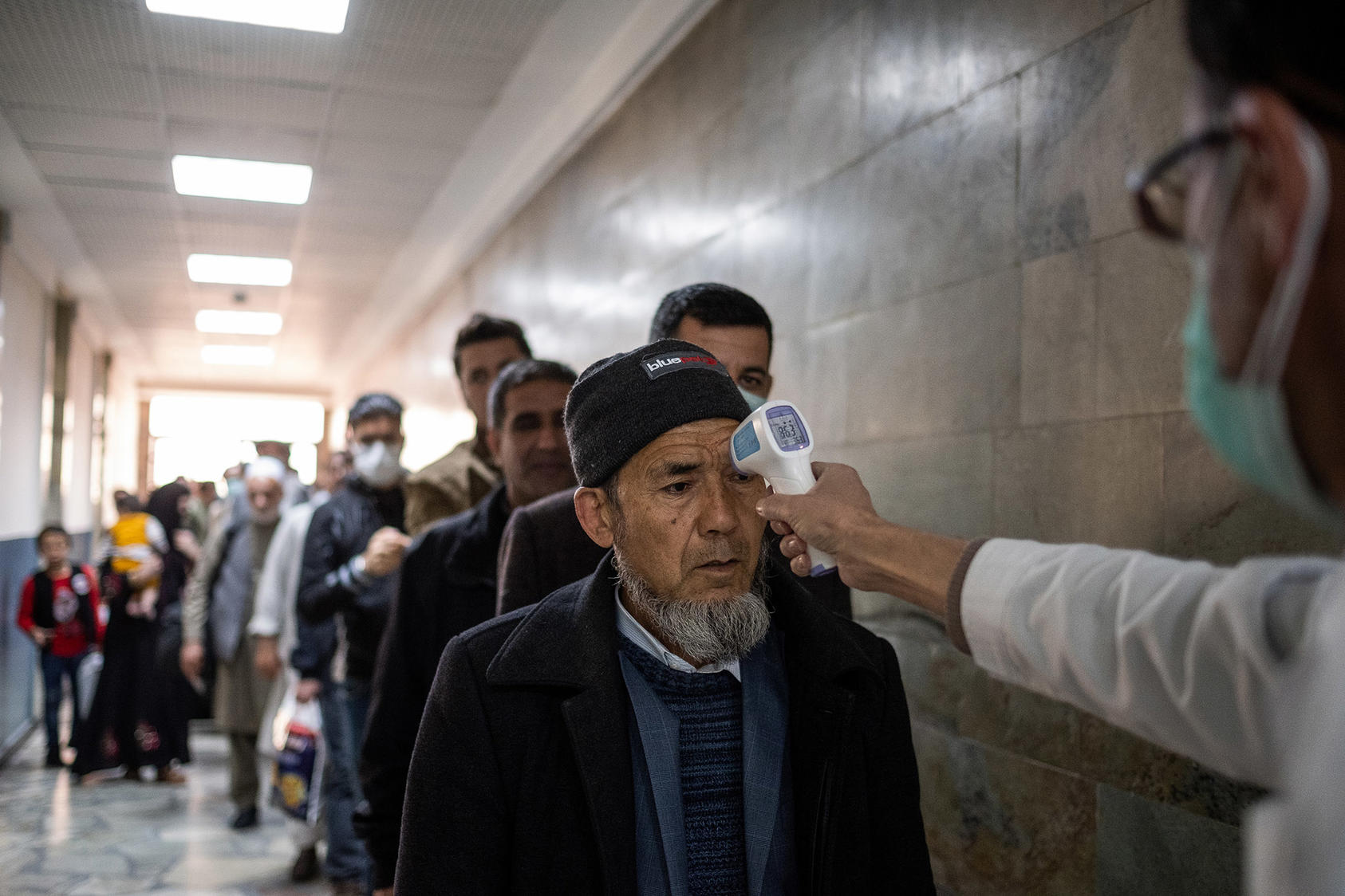 Travelers have their temperature checked before entering the airport in Kabul, Afghanistan, Monday, March 16, 2020. (Jim Huylebroek/The New York Times)