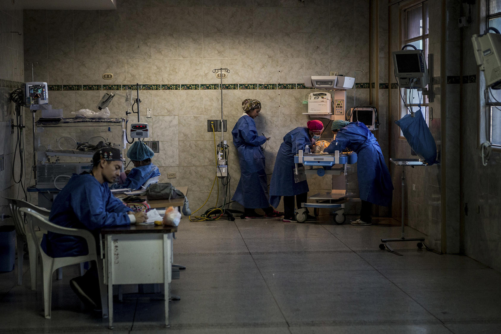 El personal médico trabaja en la sala de cuidados intensivos neonatales del Hospital Central en San Cristóbal, Venezuela, en 2019. Carece uniformes, desinfectantes y líquidos intravenosos que familias deben proveer. (Meridith Kohut / The New York Times)