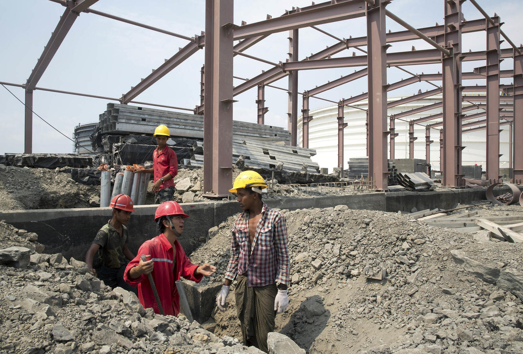 A Chinese worker tries to communicate with Burmese workers near new oil storage tanks for a Chinese oil and gas pipeline project, on Myanmar's Maday Island, May 4, 2013. (Sim Chi Yin/The New York Times)
