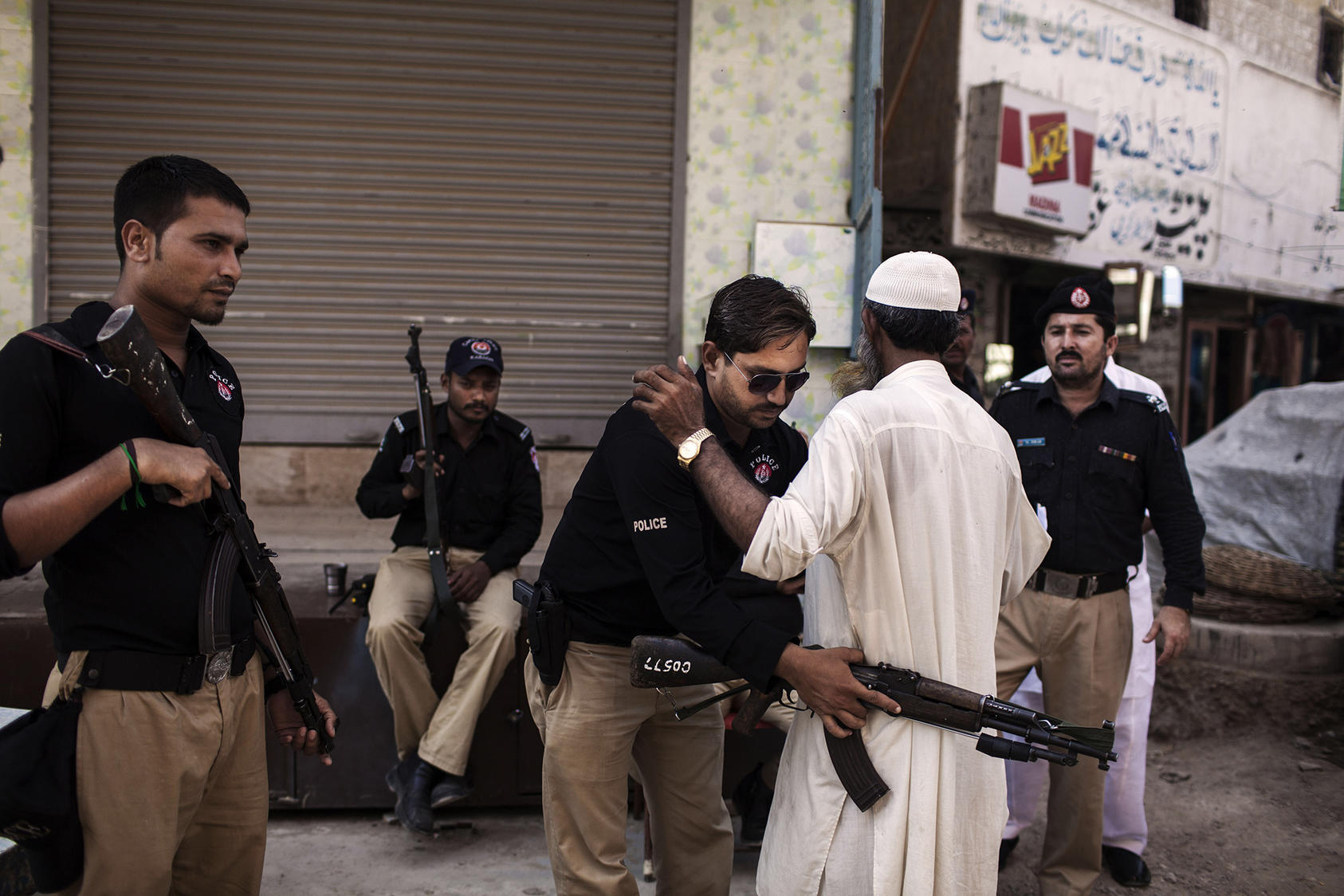A police officer searches a voter during a repeat of the parliamentary election in Karachi, Pakistan, May 19, 2013. (Diego Ibarra Sanchez/The New York Times)