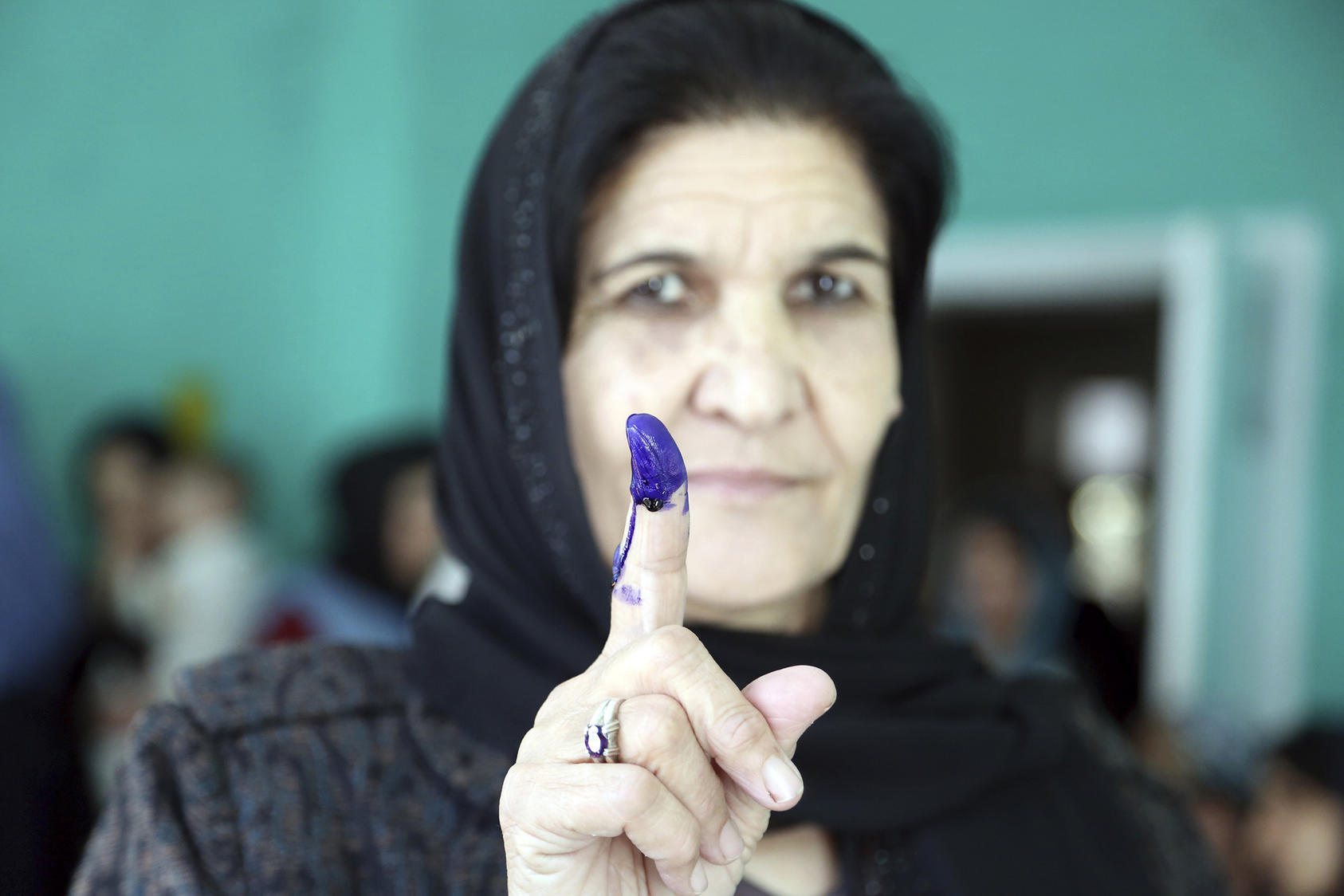 An Afghan woman shows her inked finger after casting her vote at a polling station during the parliamentary elections in Kabul on October 20, 2018. (Rahmat Gul/AP)