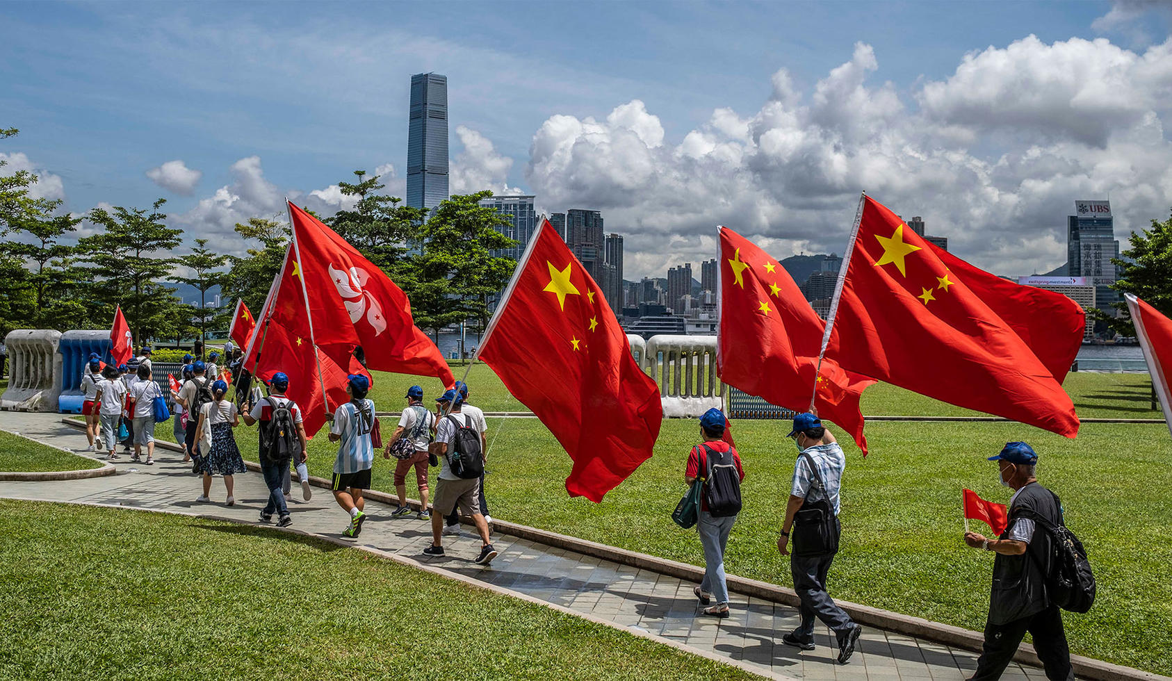 Supporters of the government in Beijing, carrying the flag of China, march in Hong Kong after new national security law goes into effect. June 30, 2020. (Lam Yik Fei/The New York Times)