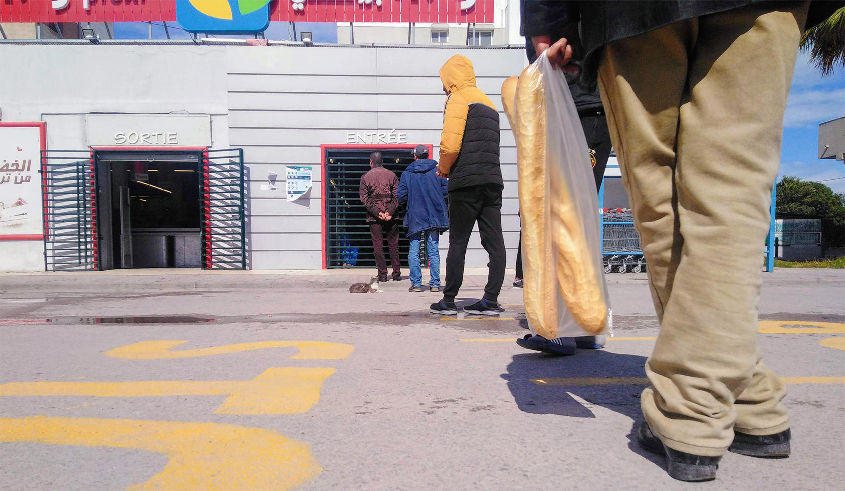 Tunisians wait in line to enter a grocery store amid COVID-19 lockdown measures. March 27, 2020. (Brahim Guedich)