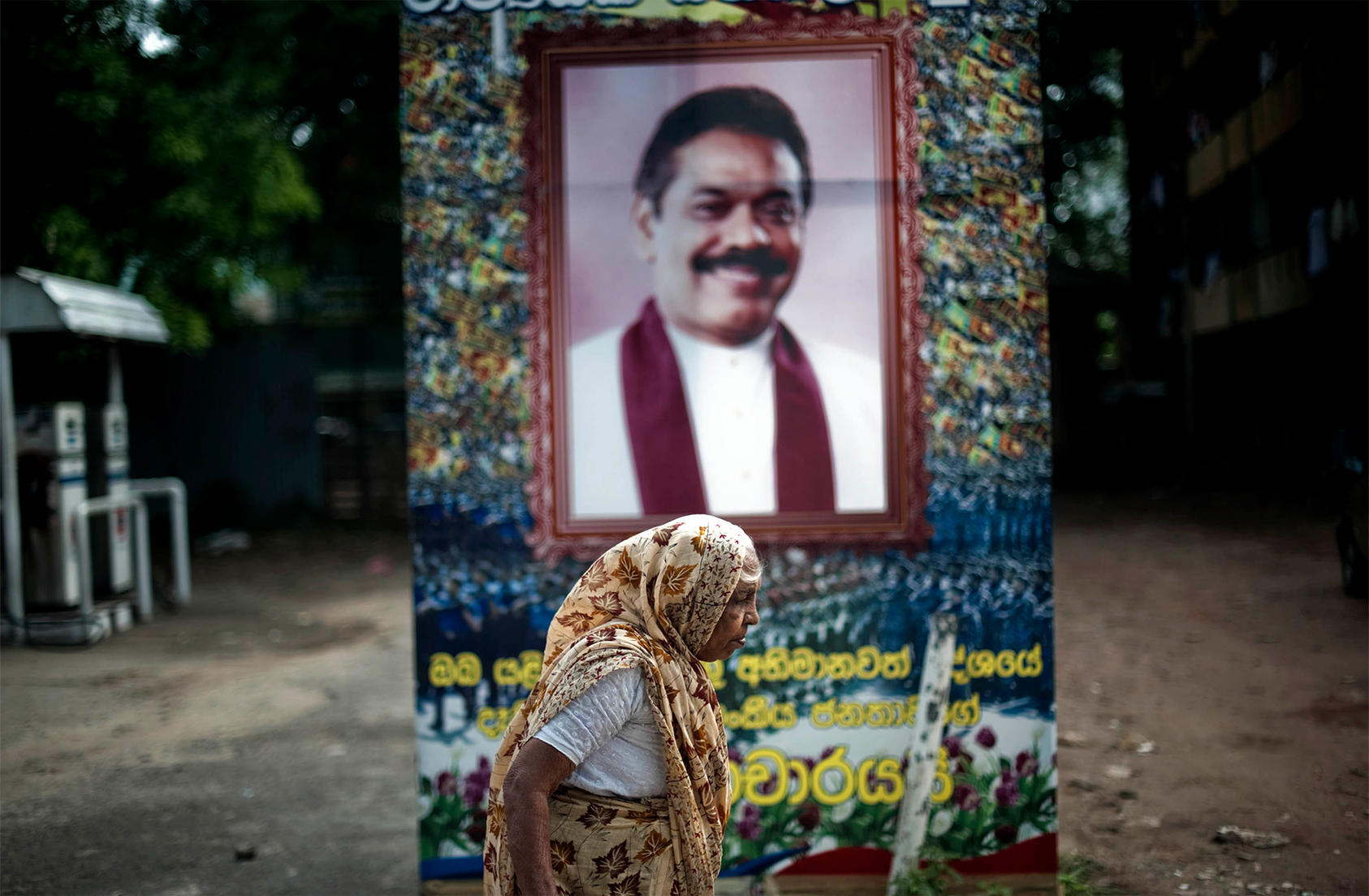 A woman walks past a poster celebrating former President and current Prime Minister Mahinda Rajapaksa in Colombo, Sri Lanka. July 4, 2009. (Keith Bedford/The New York Times)