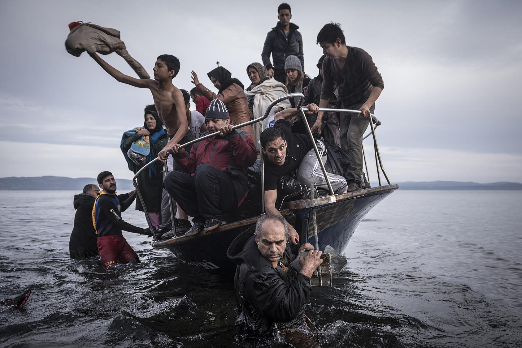 A small boat filled with migrants comes ashore after making the crossing from Turkey, near the village of Skala, on Lesbos island in Greece. Nov. 16, 2015. (Sergey Ponomarev/The New York Times)