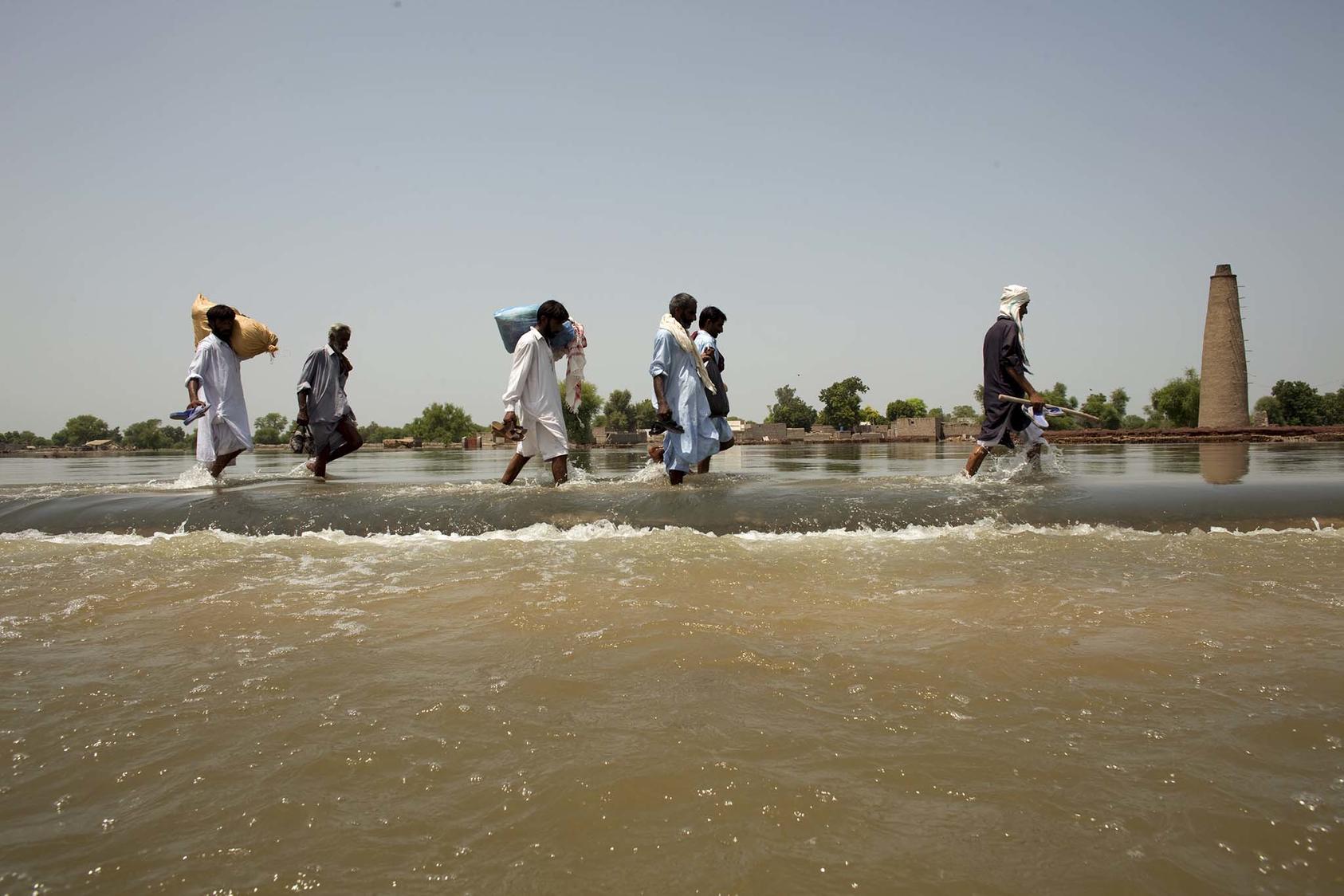 Pakistanis walk across the main highway on the border of the Sindh and Punjab provinces of southern Pakistan, Aug. 22, 2010. (Tyler Hicks/The New York Times)