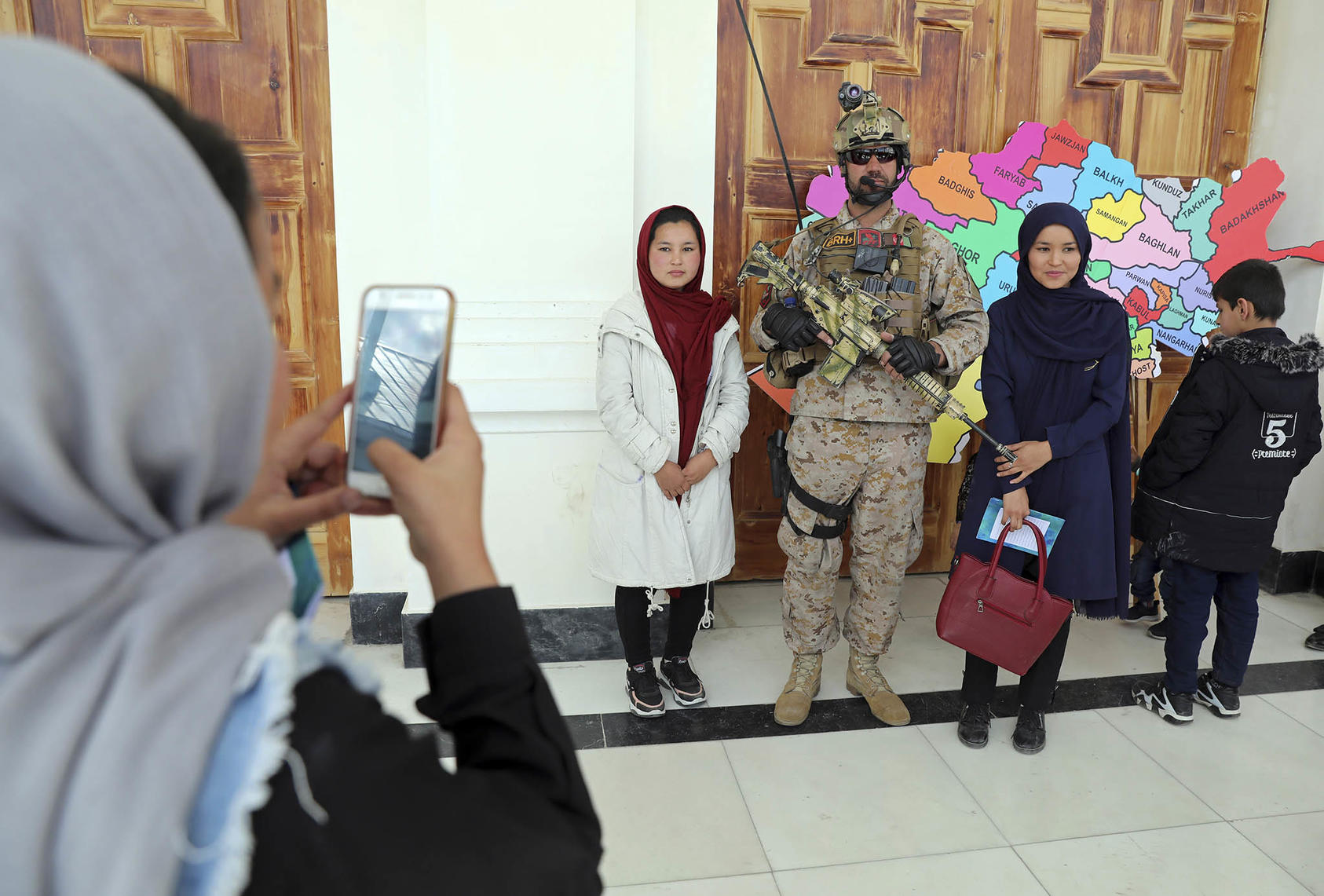 People take a picture with a soldier at the Afghan Security Forces Exhibition in Kabul, Afghanistan, on March 3, 2021. (Rahmat Gul/AP)